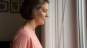 Eine Frau im Profil vor einem hellen Fenster.