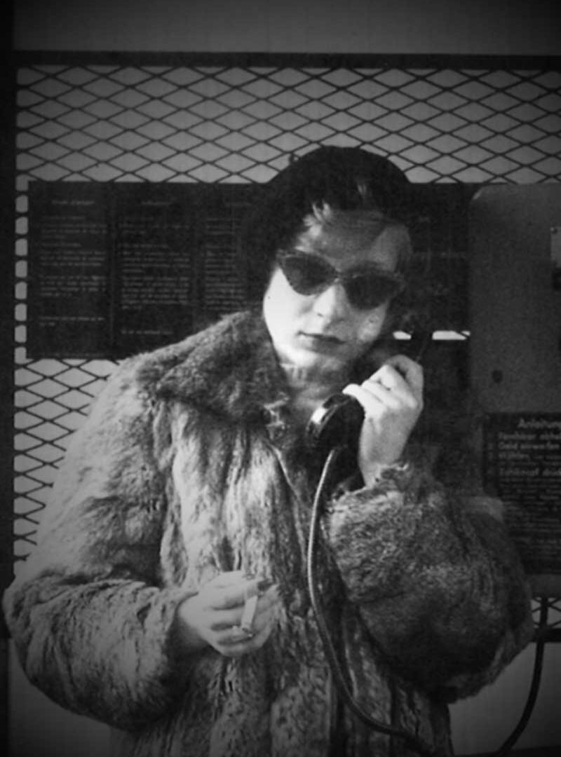 Eine Frau im Pelzmantel telefoniert. Titel: Nicht jung. Nicht leise