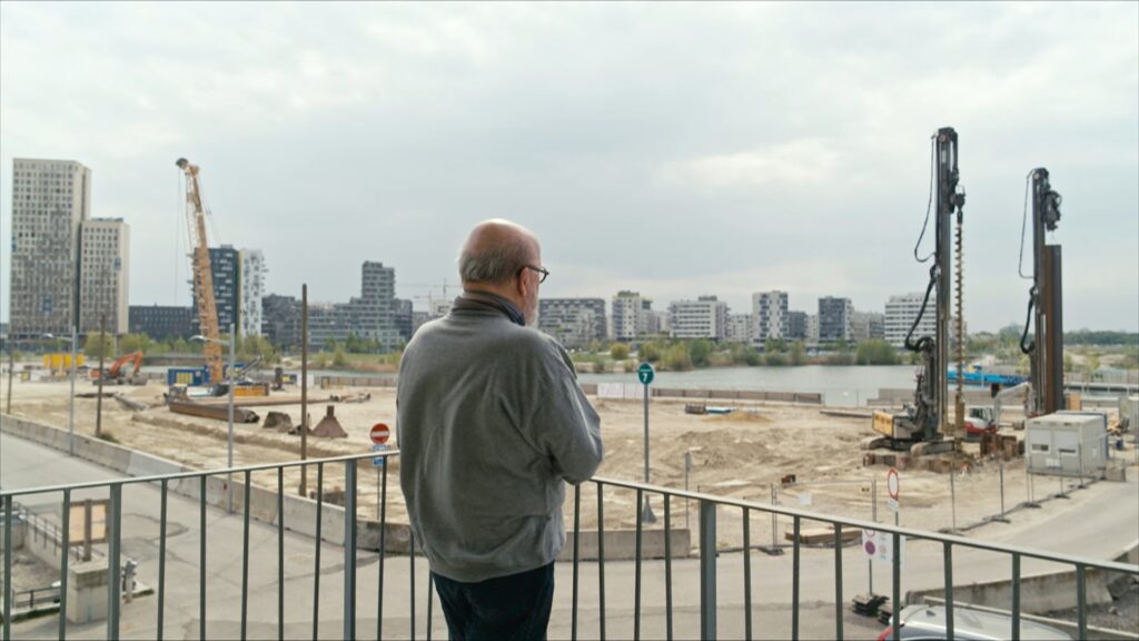 A resident of the shared flat WG Melange looking out over the construction sites of Vienna's Seestadt