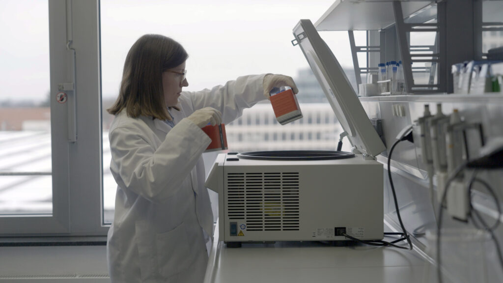 Scientist placing samples into a centrifuge in a lab